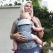 Beco Gemini Flamingo baby carrier used by mother to carry a baby in the front