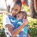 Beco Gemini Baby Carrier Over The Rainbow used by lady to hug her baby