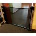 Smart Retract Retract-A-Gate Retractable Baby & Pet Safety Gate in black used at a doorway