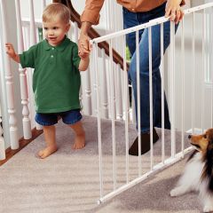 Kidco G2000 Safeway Wall Mounted Safety Gate White used by mom with baby in arm climbing upstairs at the top of stairs