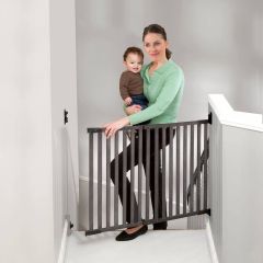 Kidco G2304 Angle Mount Bamboo Safeway Wall Mounted Safety Gate Gray used by mom with baby in arm climbing upstairs at the top of stairs