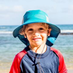 Boy at beach wearing a Sunday Afternoons UPF 50+ Sun Protection Kids Play Hat in Everglade