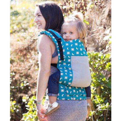 Lady back carries a toddler in a Tula Toddler Coast Aurora Carrier