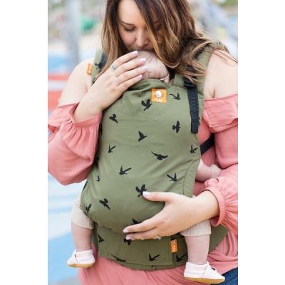 Mother kisses baby sleeping in a Tula Free to Grow Soar Baby Carrier